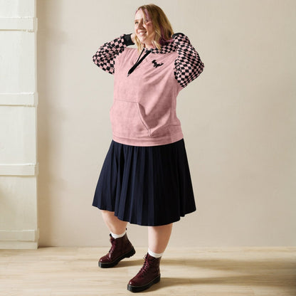 Person wearing a pink hoodie, black skirt, and maroon boots indoors.