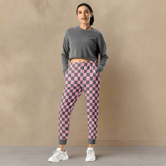Woman wearing a gray long-sleeve top and pink checkered pants against a beige background