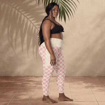 Woman wearing pink and white checkered pants against a beige wall.