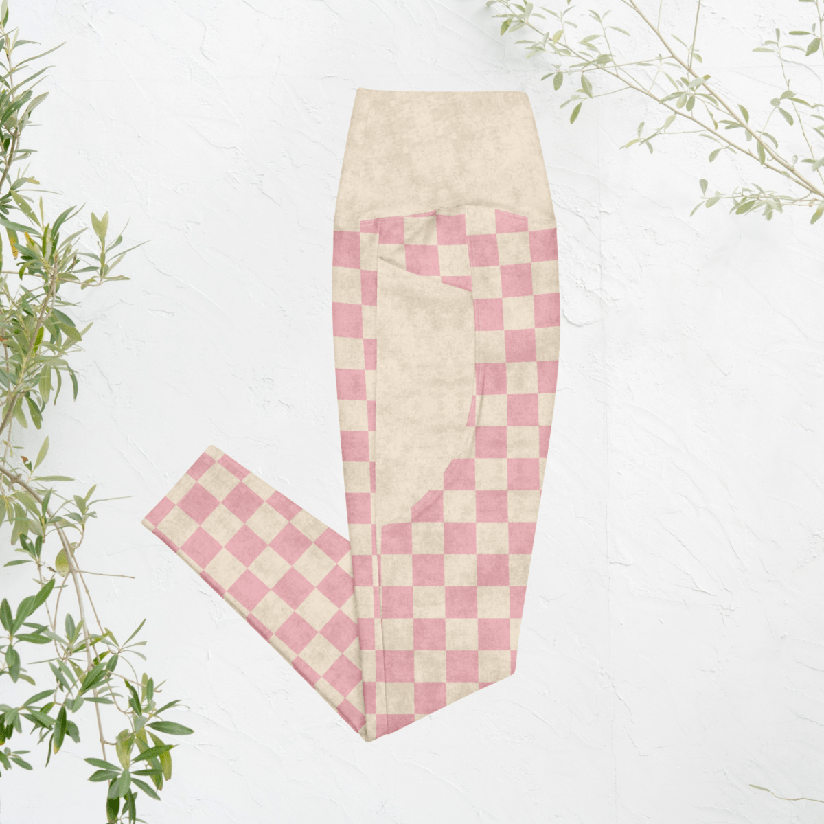 Pink and beige checkered pants on a white background with green leaves.
