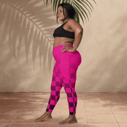Woman wearing pink checkered leggings and black sports bra standing against a beige wall.