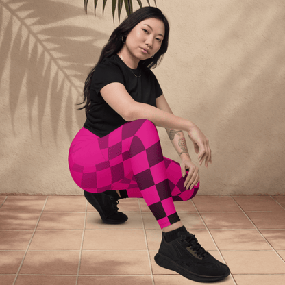 Person wearing pink and black checkered leggings sitting on a tiled floor.
