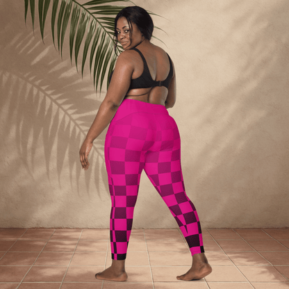 Person wearing pink checkered leggings and black sports bra against a beige wall.