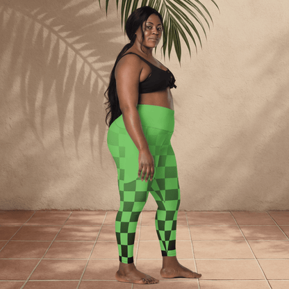 Woman wearing green checkered leggings and black top standing against a beige wall.