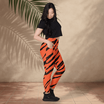 Person wearing orange and black striped pants against a beige wall.