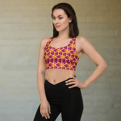 Woman wearing a geometric patterned sports bra and black leggings against a neutral background
