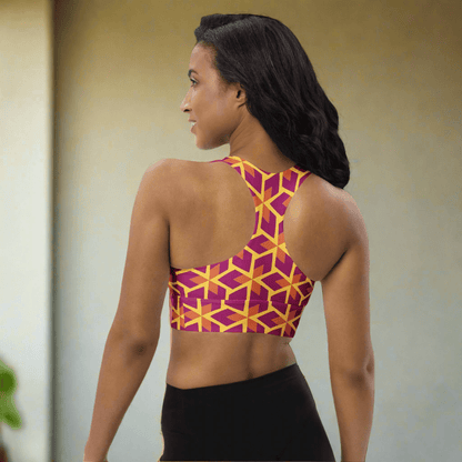 Woman wearing a colorful geometric-patterned sports bra on a white background