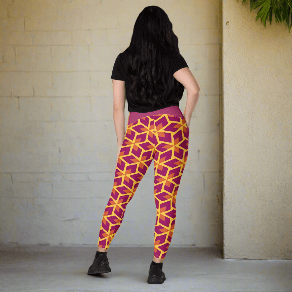 Person wearing a black t-shirt and purple geometric patterned leggings on a neutral background
