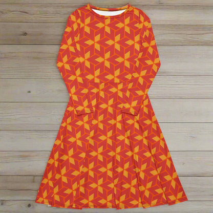 Orange and yellow geometric patterned dress on a wooden surface