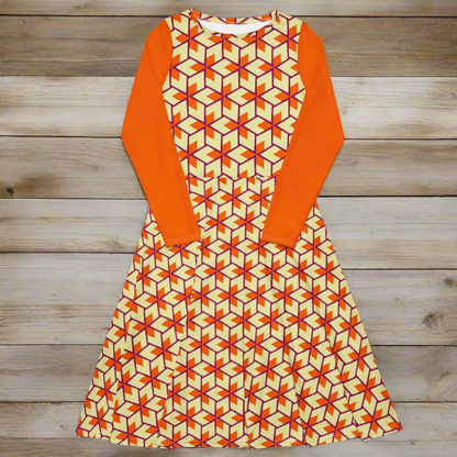 Flat lay of the full dress from the front, displaying the triangular print across the entire skirt and bodice. The long sleeves are folded inward across the dress and appear as solid orange panels on each side.