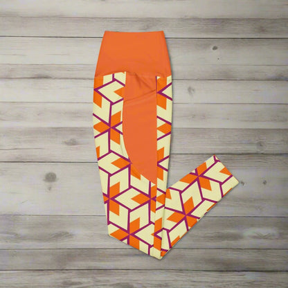 Orange Retro Geometric High-Waisted UPF 50+ Pocket Leggings 2XS–6XL | Dopamine Dressing Recycled Yoga Pants | Moisture Wicking Compression, folded and laying on a wooden surface