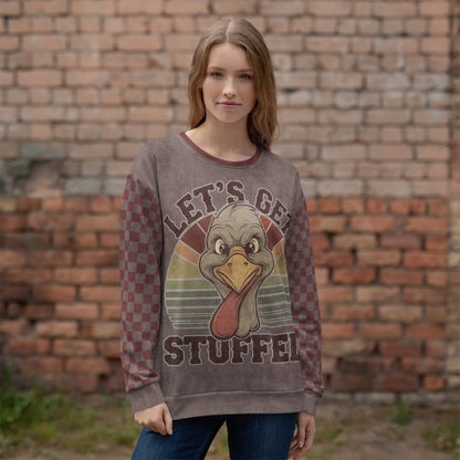Person wearing a sweater with a turkey graphic and 'Let's Get Stuffed' text against a brick wall.