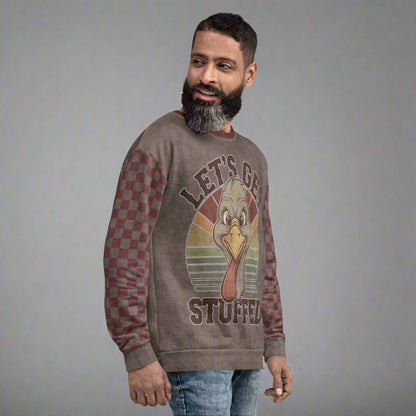 Man wearing a sweater with a graphic design of a turkey and text 'Let's Get Stuffed' on a neutral background
