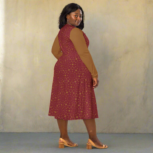 Woman facing backward, glancing over her shoulder while wearing a scarlet midi dress with golden dots and solid gold sleeves. She stands confidently in tan heeled sandals.