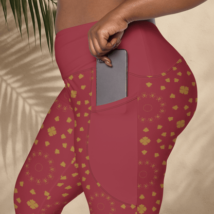 Red leggings with gold patterns worn by a person, held against a neutral background.
