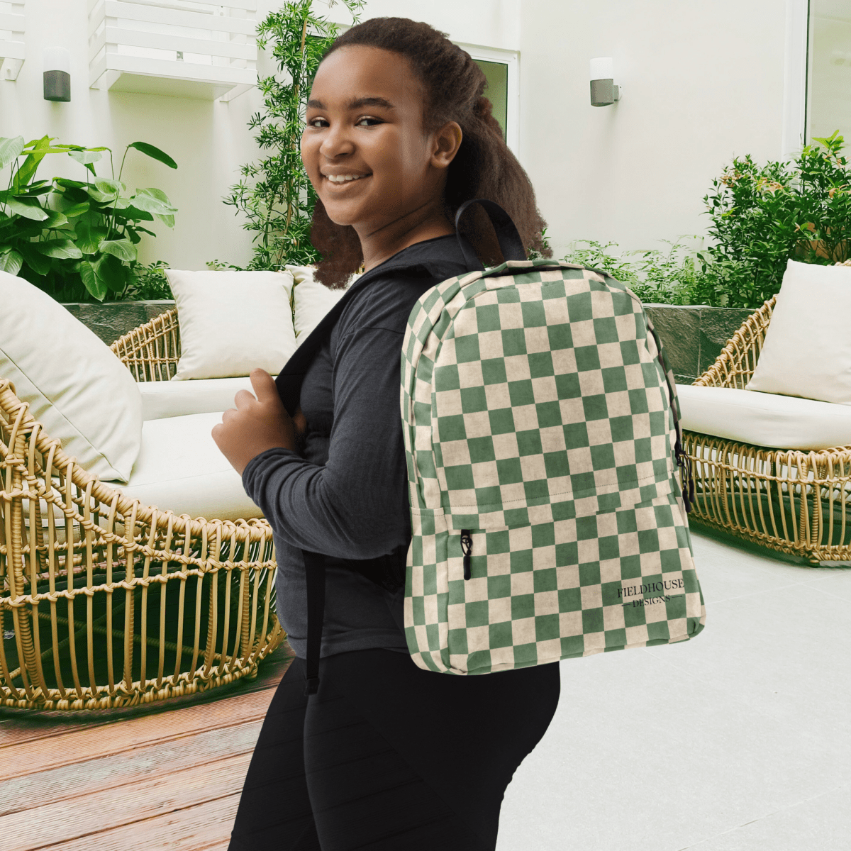 Person wearing a green and beige checkered backpack in an outdoor setting