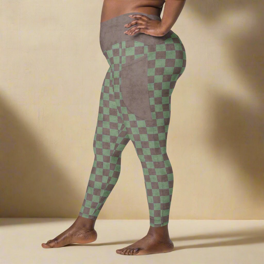 Person wearing green and brown checkered leggings on a neutral background