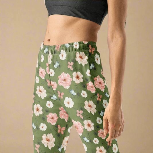 Green floral patterned joggers worn by a person on a beige background