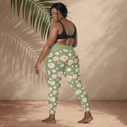 Woman wearing green floral leggings against a beige wall.