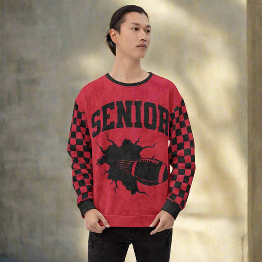 Person wearing a red sweatshirt with 'SENIOR' , football breaking through the middle and checkered design 