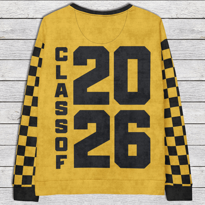 Yellow sweatshirt with 'Class of 2026' text on a wooden surface