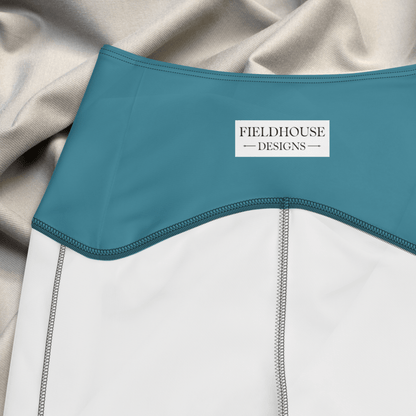 Close-up of a garment with blue waistband and 'Fieldhouse Designs' label, draped over beige fabric.