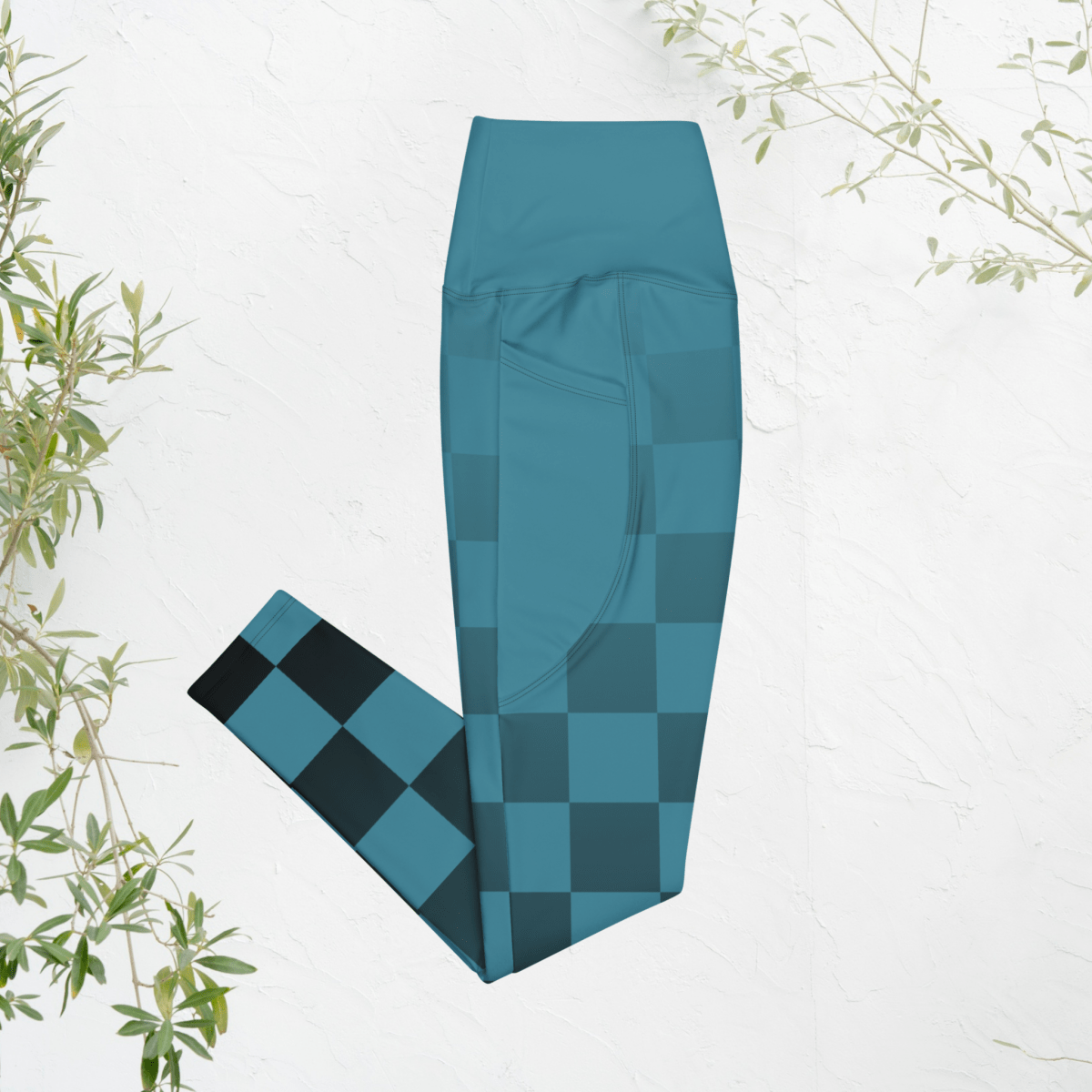 blue checkered leggings on a white background with green leaves.