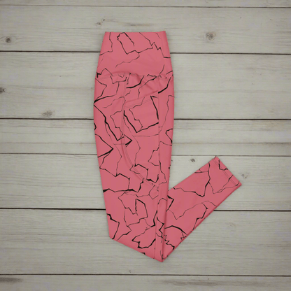 Pink leggings with black abstract pattern on a wooden surface