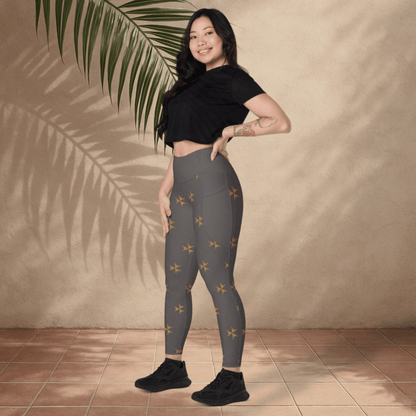 Woman wearing gray leggings with a subtle pattern, standing against a beige wall with a palm leaf.