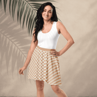 Woman wearing a white top and checkered skirt standing against a beige background with a palm leaf.