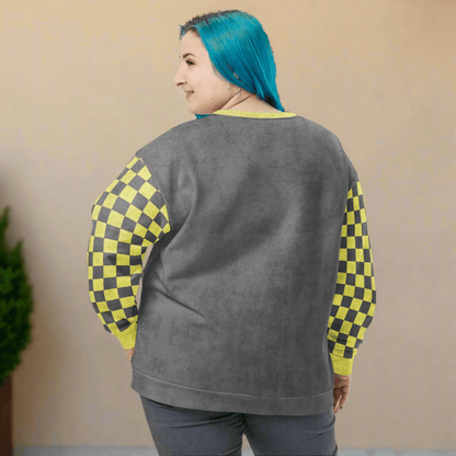 Person wearing a gray sweatshirt with checkered sleeves on a neutral background