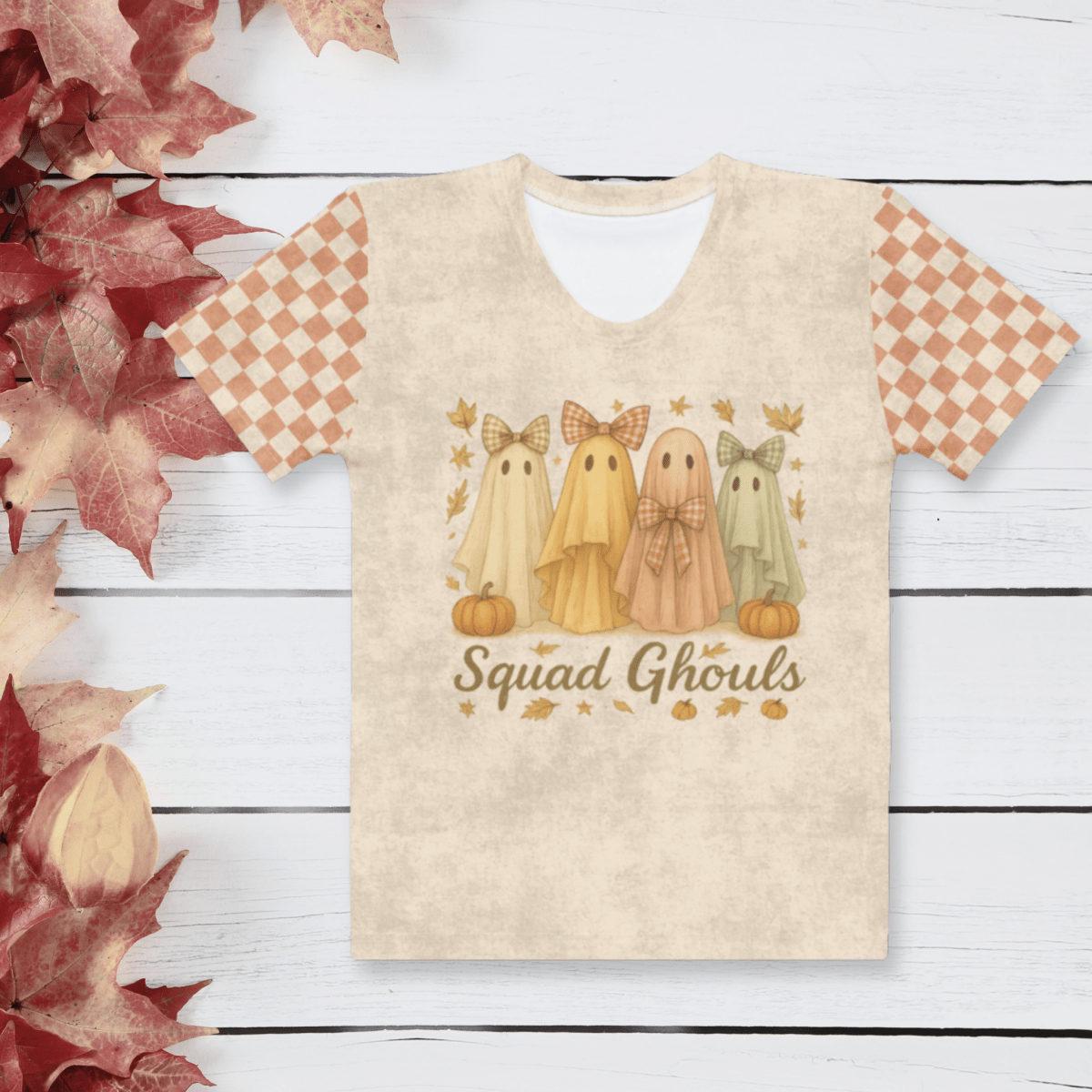 T-shirt with ghost design and 'Squad Ghouls' text on a wooden surface with fall leaves.