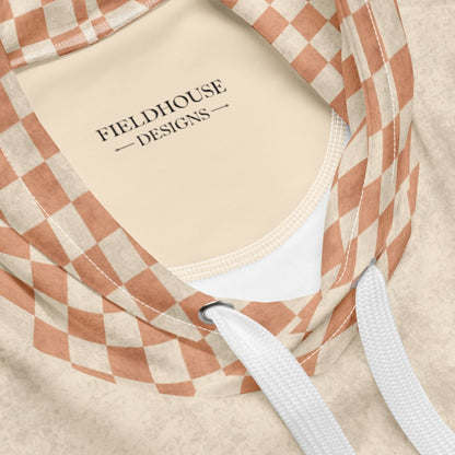 Close-up of a beige hoodie with a checkered pattern and 'Fieldhouse Designs' branding.