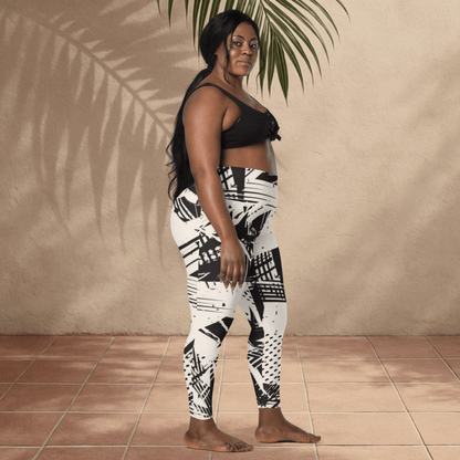 Woman wearing black and white patterned leggings against a beige wall.