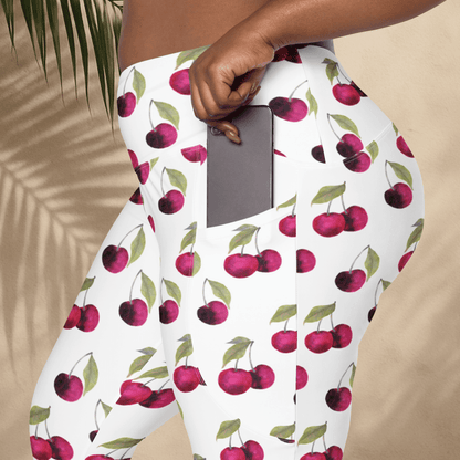 Person wearing cherry-patterned pants holding a phone.