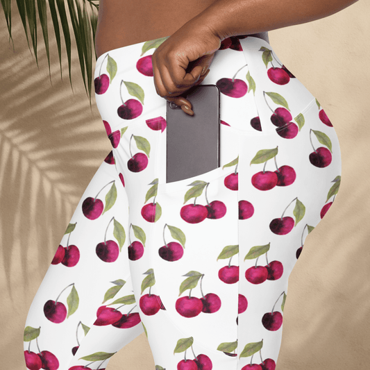 Person wearing cherry-patterned pants holding a phone.