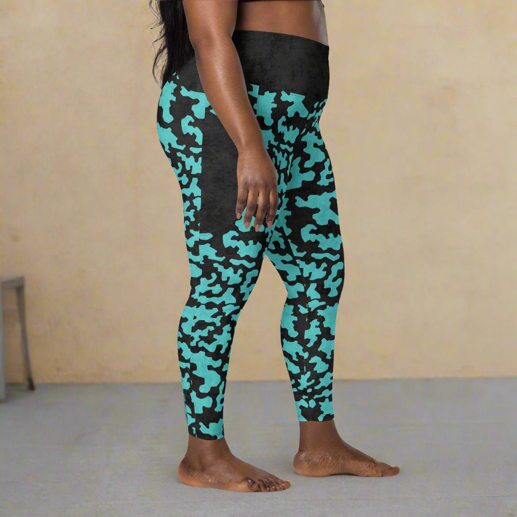Person wearing black and teal camouflage leggings on a beige background