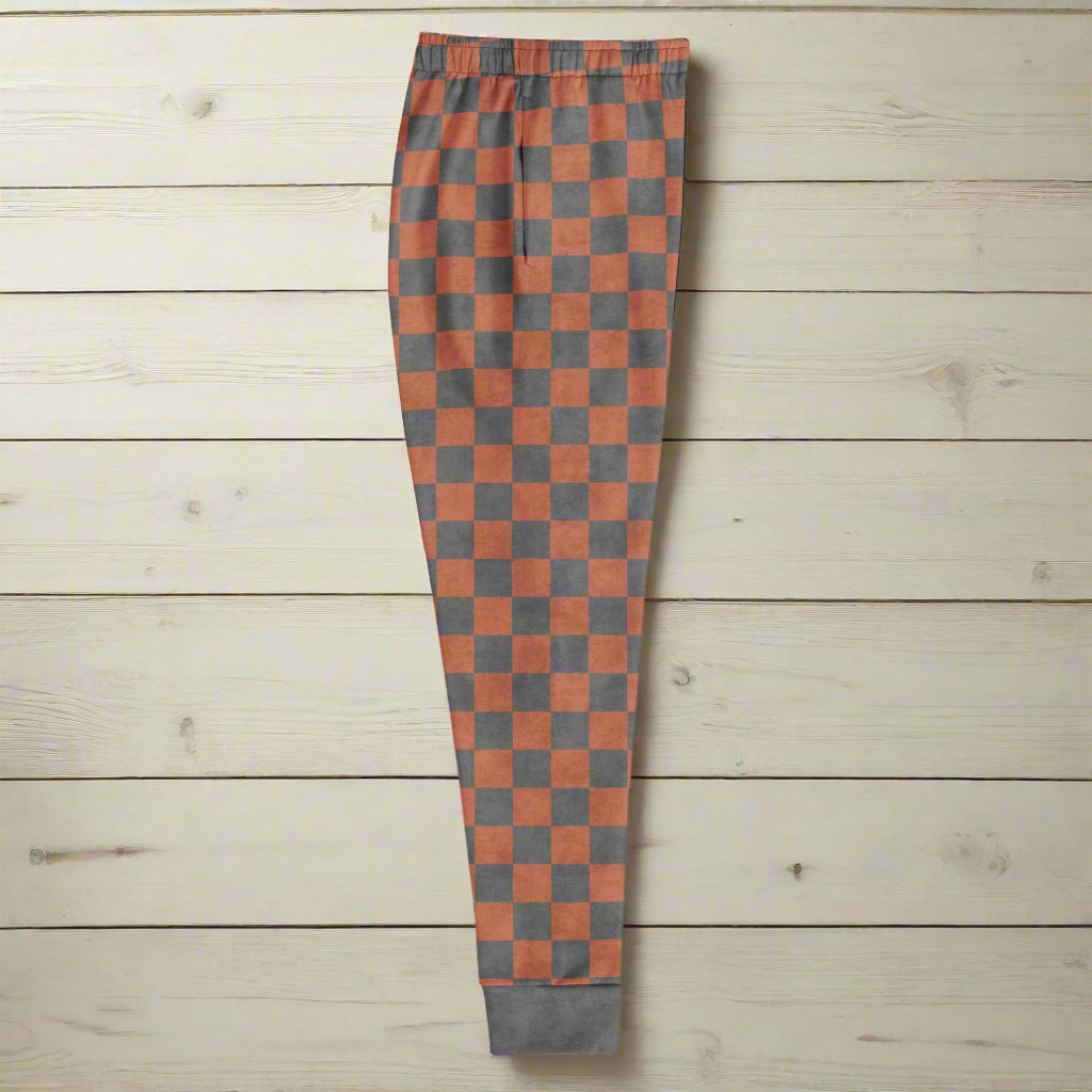 Checkered pants with terracotta and gray pattern on a wooden floor