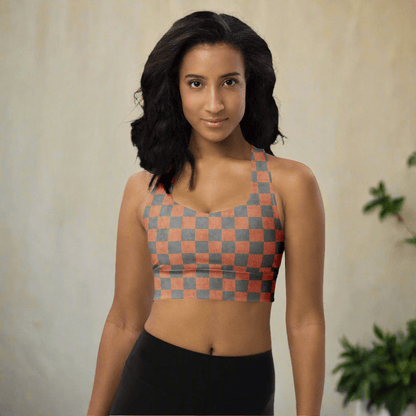 Woman wearing a checkered sports bra and black leggings on a neutral background