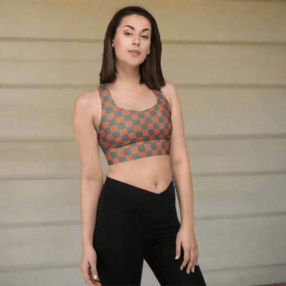 Woman wearing a patterned sports bra and black leggings against a neutral background