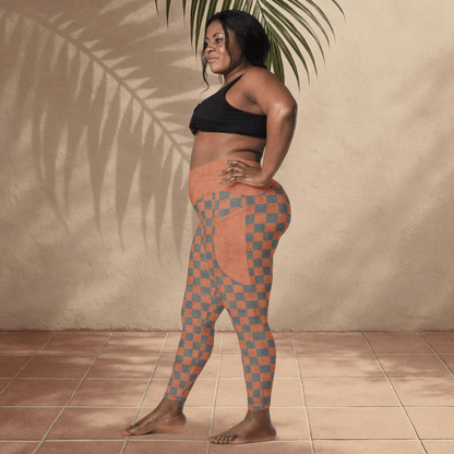 Woman wearing checkered leggings and black sports bra against a beige wall.
