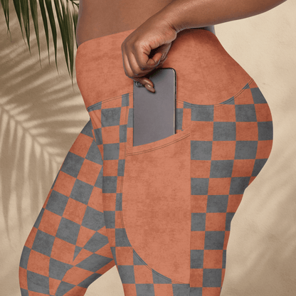 Person wearing checkered pants with a pocket holding a phone, against a neutral background.