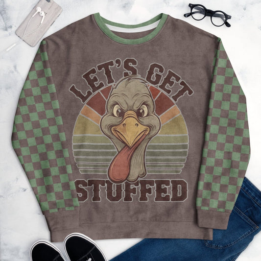 Sweatshirt with a turkey graphic and 'Let's Get Stuffed' text on a marble surface.
