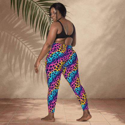 Person wearing colorful leopard print leggings standing against a beige wall.