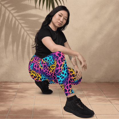 Person wearing colorful leopard print pants and black shoes on a beige background