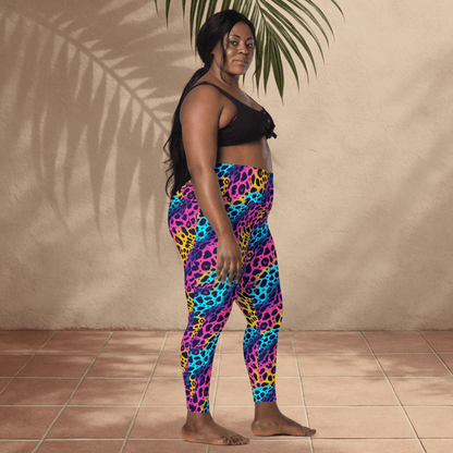 Woman wearing colorful leopard print leggings against a beige wall.