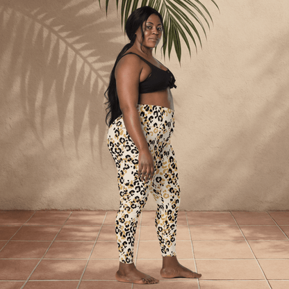 Woman wearing leopard print pants and a black top against a beige wall.