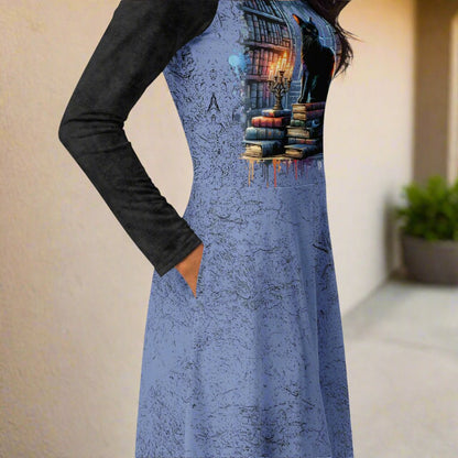 Blue dress with a graphic design of books and a black cat